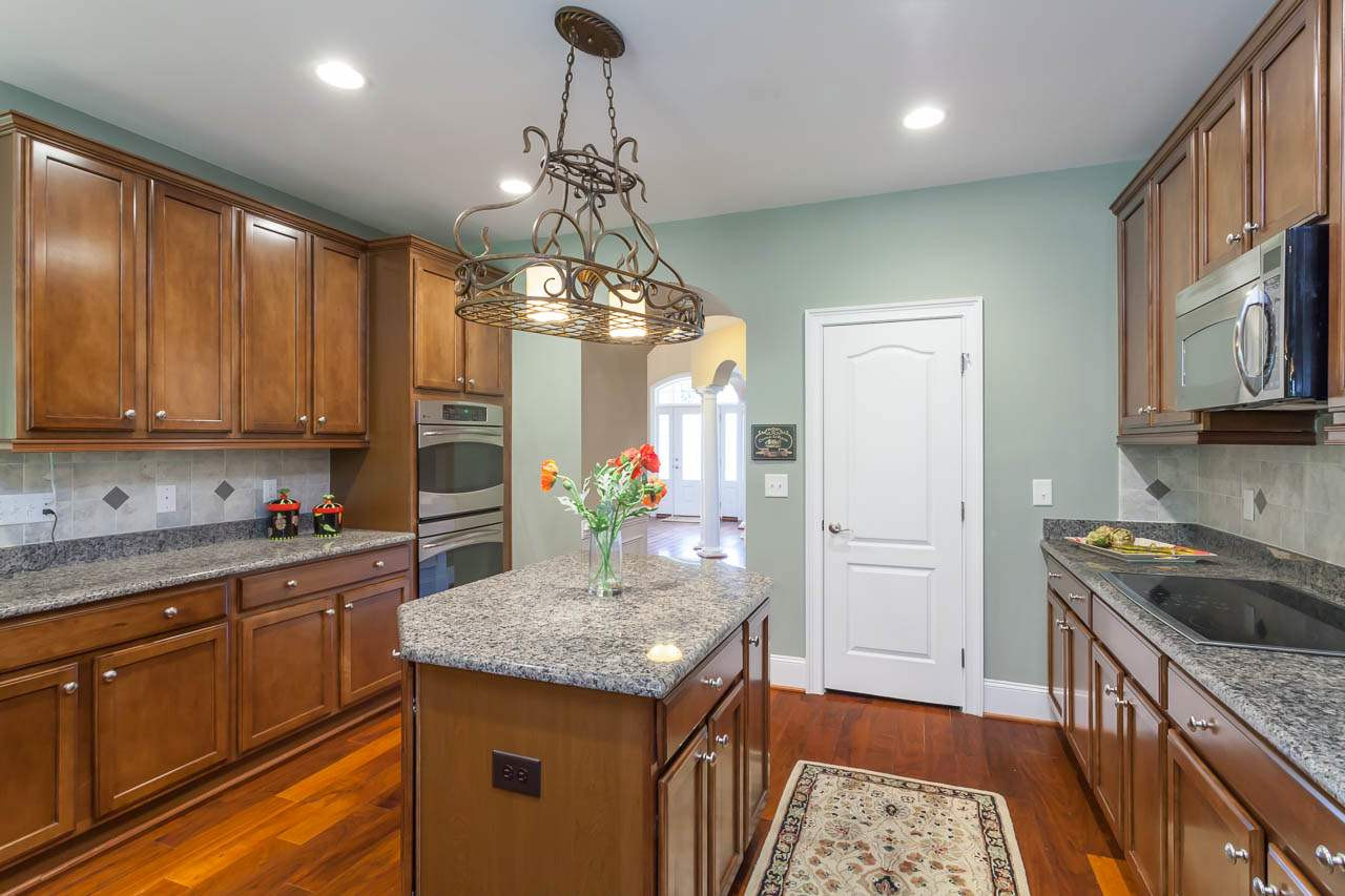 8000 Jessamine Way Raleigh, NC 27612 - Photo 8 of 25 The door at the back of this photo is the door to the large walk in pantry and its many rows of wood shelving. Kitchen and Pantry