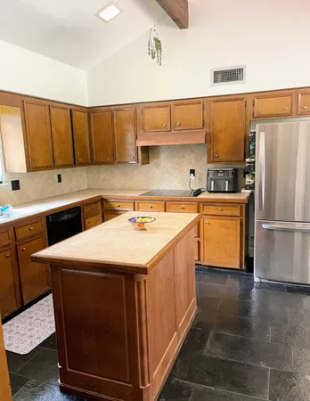 a kitchen with stainless steel appliances a sink a stove a refrigerator and cabinets