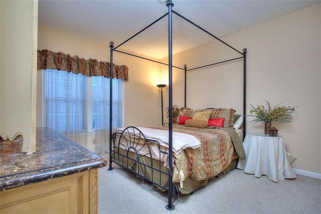 240 Renaissance Parkway Northeast, Unit 116 Atlanta, GA 30308 - Photo 28 of 42 a bed sitting in a bedroom next to a window and a wooden floor