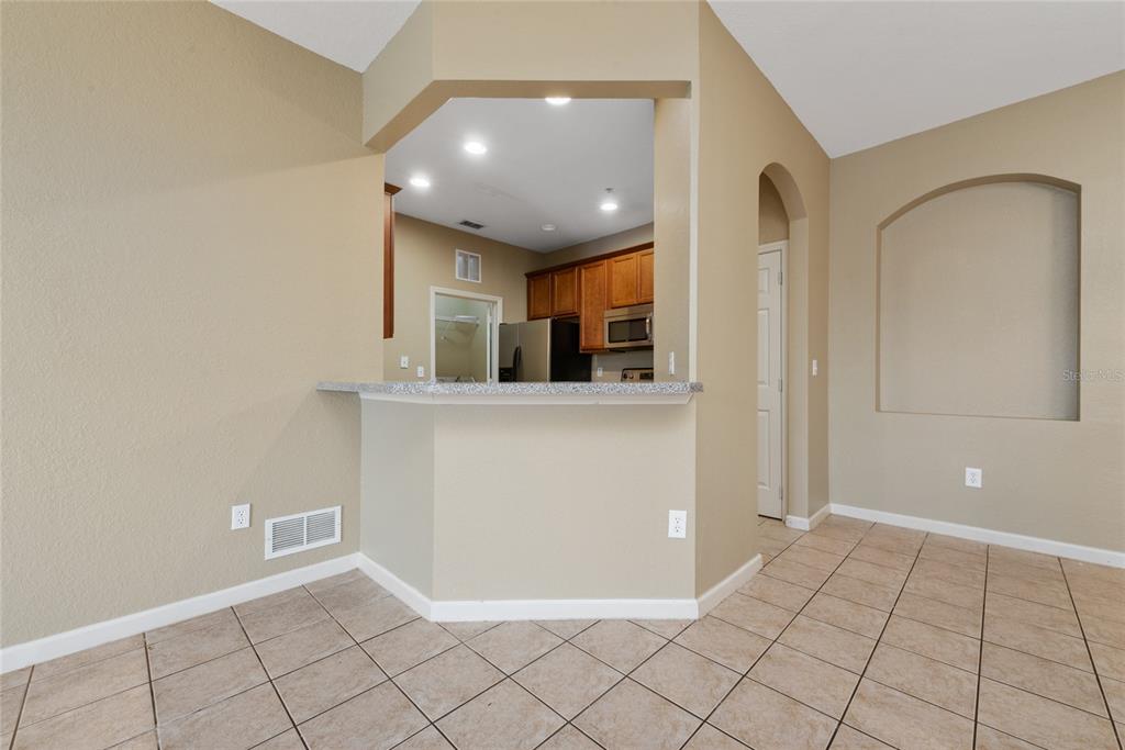 3051 Greystone Loop, Unit 201 Kissimmee, FL 34741 - Photo 6 of 20 a view of a kitchen with furniture and an entryway