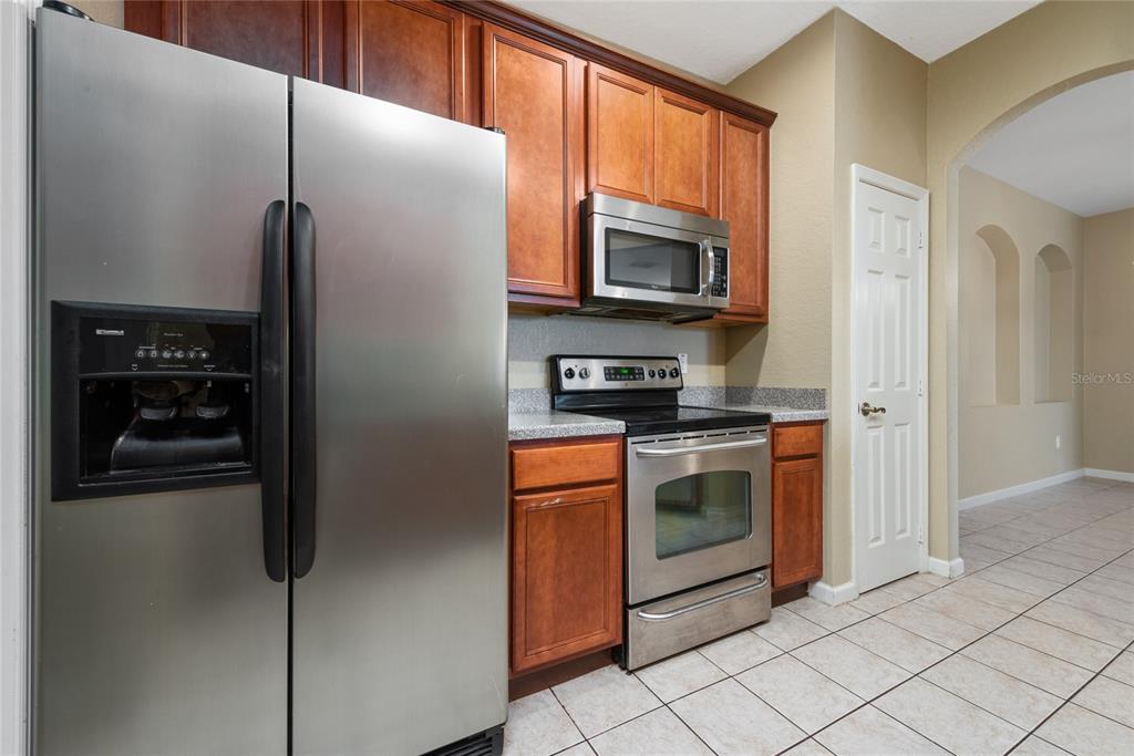 3051 Greystone Loop, Unit 201 Kissimmee, FL 34741 - Photo 9 of 20 a kitchen with stainless steel appliances granite countertop a refrigerator and a stove top oven