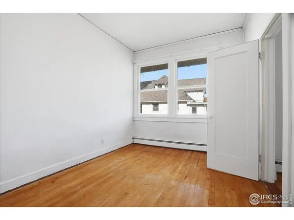 a view of an empty room with wooden floor