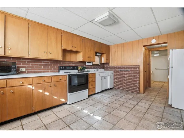 a kitchen with granite countertop a stove top oven sink and cabinets