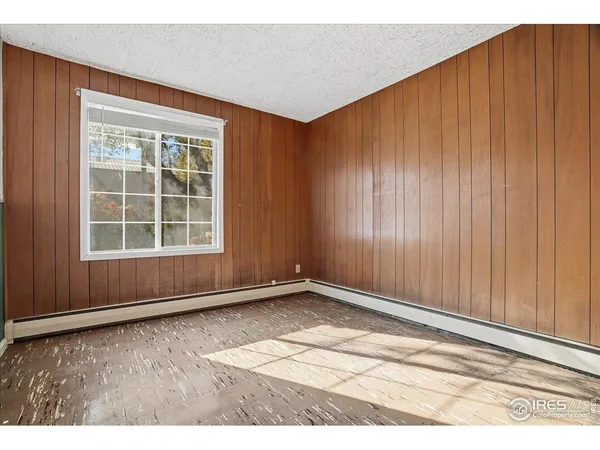 a view of an empty room with wooden floor and stairs