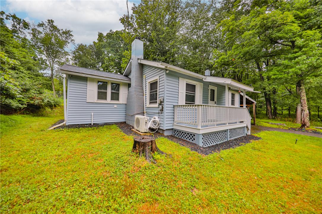 5599 Minks Pond Road Bushkill, PA 18324 - Photo 30 of 64 A quaint residence nestled among mature trees offers a welcoming front porch and a secluded feel.
