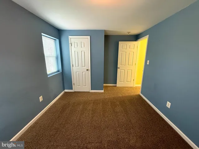 an empty room with closet and a window
