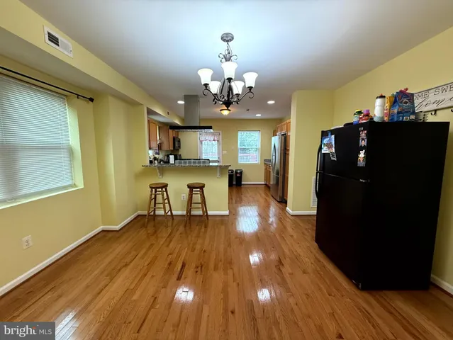 a view of a kitchen with dining table and stainless steel appliances