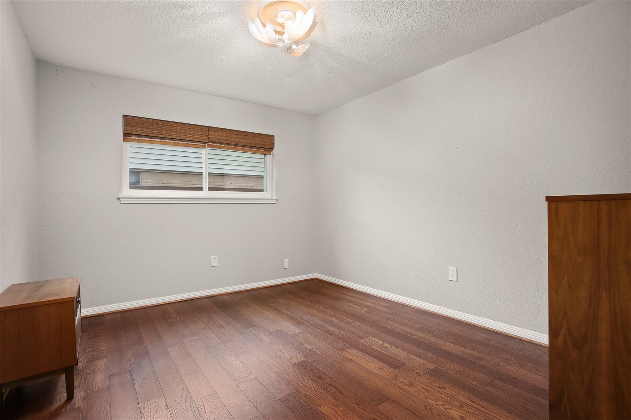 18306 Barbuda Lane Houston, TX 77058 - Photo 17 of 25 a view of an empty room with wooden floor and a window