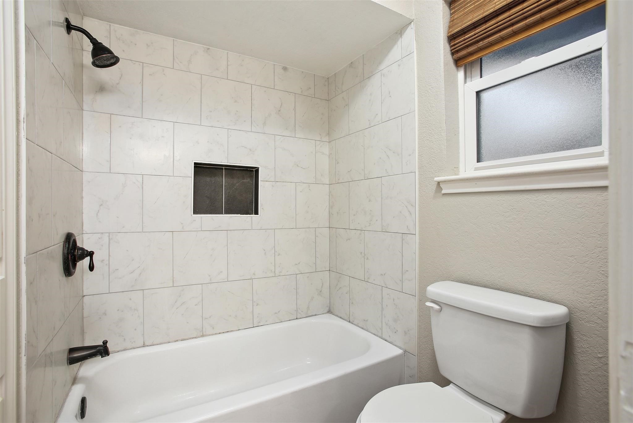 18306 Barbuda Lane Houston, TX 77058 - Photo 19 of 25 a white toilet sitting next to a bathtub