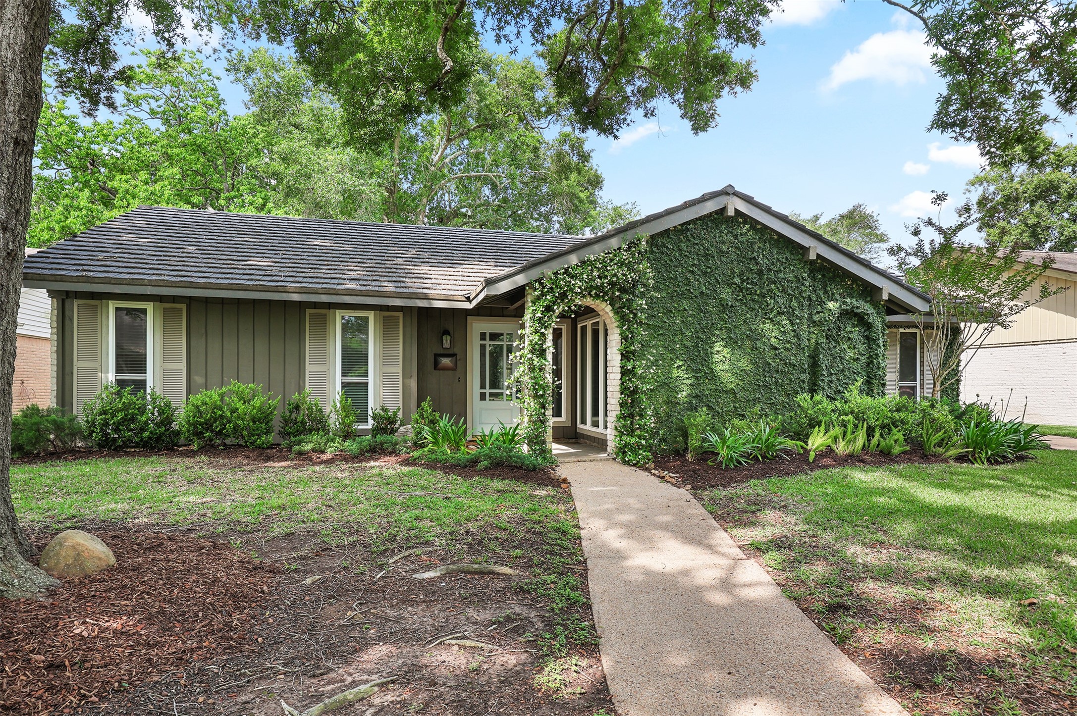 18306 Barbuda Lane Houston, TX 77058 - Photo 3 of 25 a front view of a house with a yard and potted plants