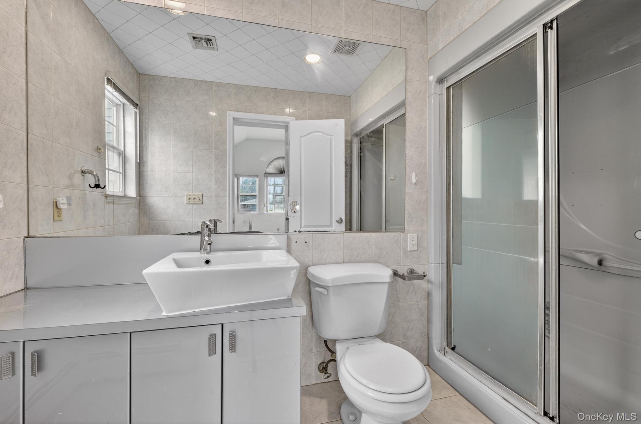 82 B Inwood Road Port Washington, NY 11050 - Photo 21 of 41 a bathroom with a sink toilet vanity and shower