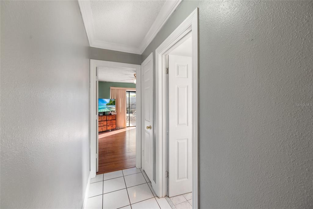 8714 Martinique Lane Port Richey, FL 34668 - Photo 15 of 34 a view of a hallway with wooden floor and a bathroom