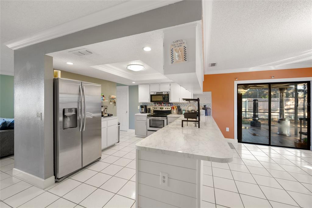 8714 Martinique Lane Port Richey, FL 34668 - Photo 17 of 34 a kitchen with stainless steel appliances granite countertop a refrigerator and a stove top oven