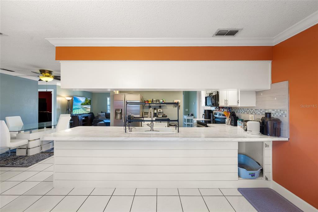8714 Martinique Lane Port Richey, FL 34668 - Photo 20 of 34 a living room with kitchen island granite countertop furniture and a fireplace