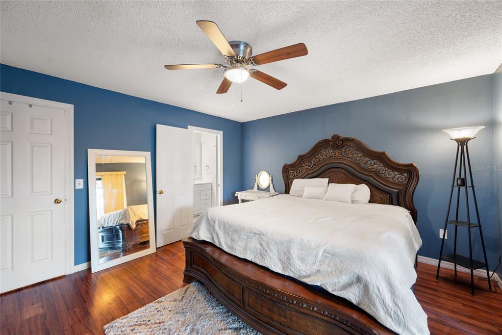 8714 Martinique Lane Port Richey, FL 34668 - Photo 23 of 34 a bedroom with a bed and wooden floor