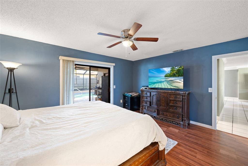 8714 Martinique Lane Port Richey, FL 34668 - Photo 33 of 34 a bedroom with a bed and a flat screen tv