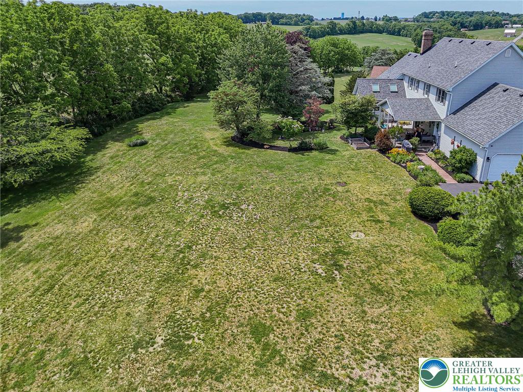4542 Springfield Drive Coplay, PA 18037 - Photo 81 of 89 An aerial perspective reveals a vast green lawn extending towards the horizon, framed by mature trees and a charming residence.