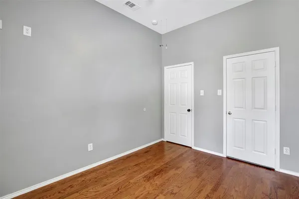 a view of an empty room with wooden floor