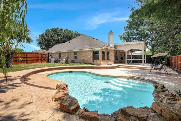 a swimming pool view with a seating space and a garden view