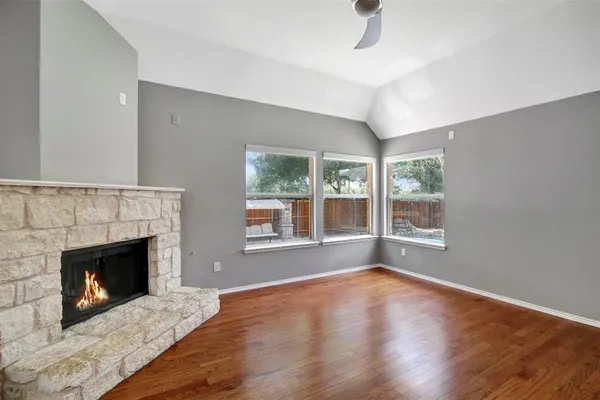 a living room with wooden floor and a fireplace