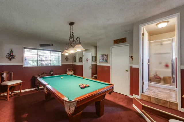 an aerial view of a residential houses with outdoor space and trees