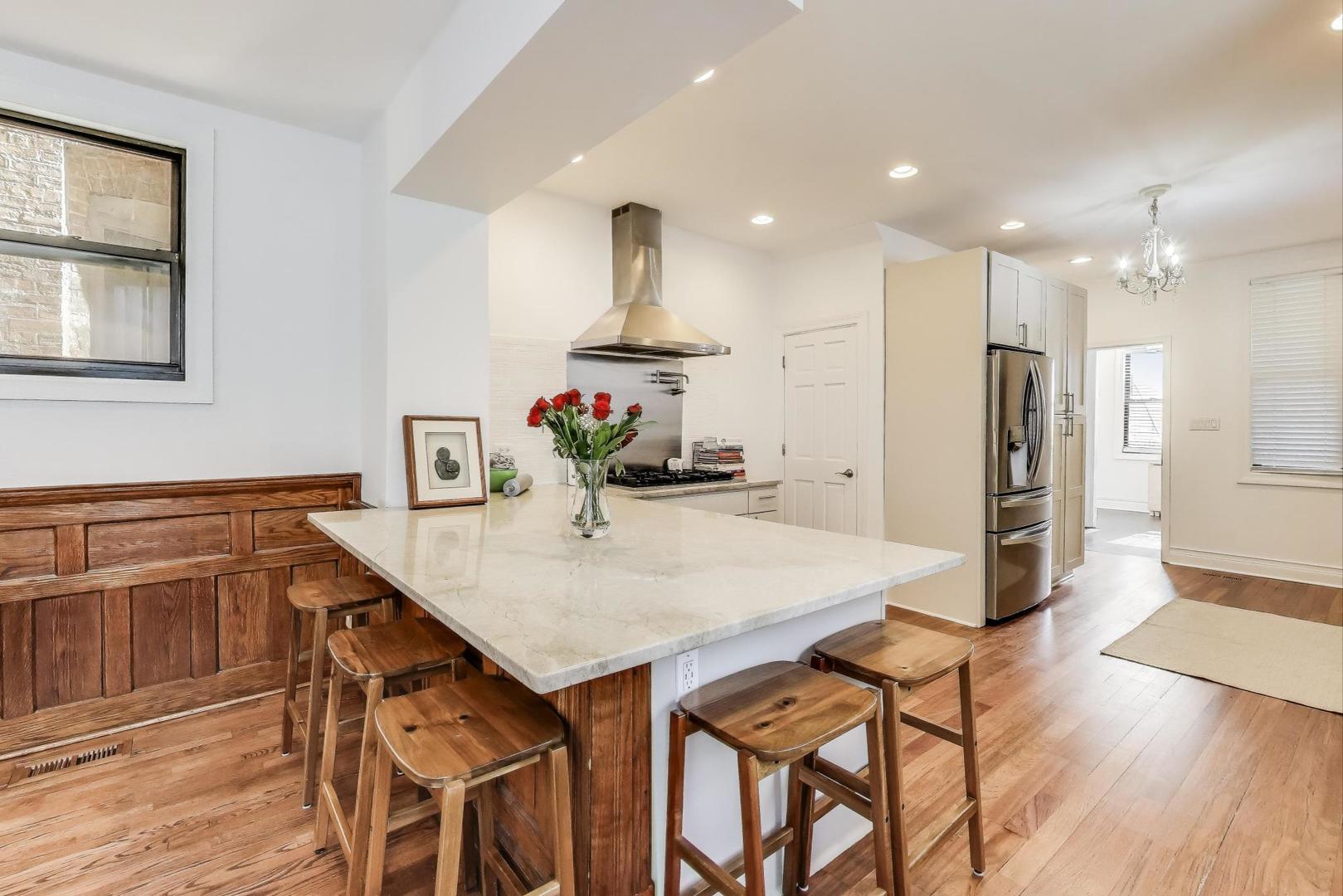4553 South Ellis Avenue Chicago, IL 60653 - Photo 12 of 62 a kitchen with stainless steel appliances kitchen island granite countertop a refrigerator and a stove top oven