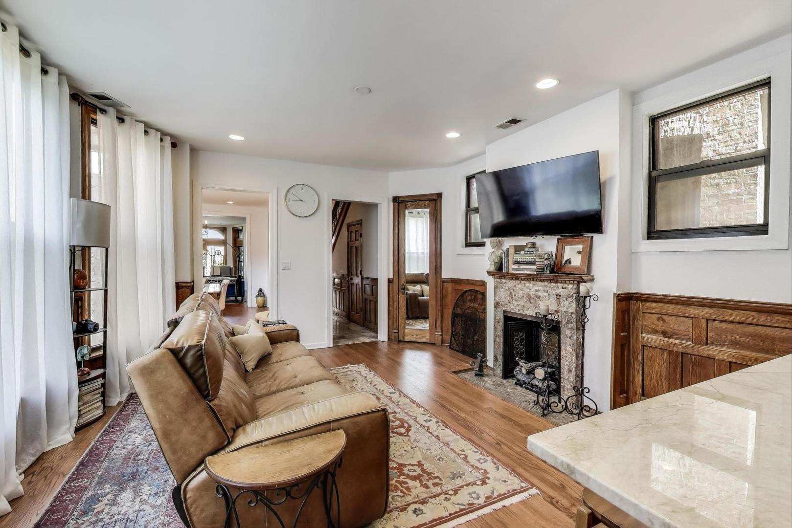 4553 South Ellis Avenue Chicago, IL 60653 - Photo 18 of 62 a living room with furniture a flat screen tv and a fireplace
