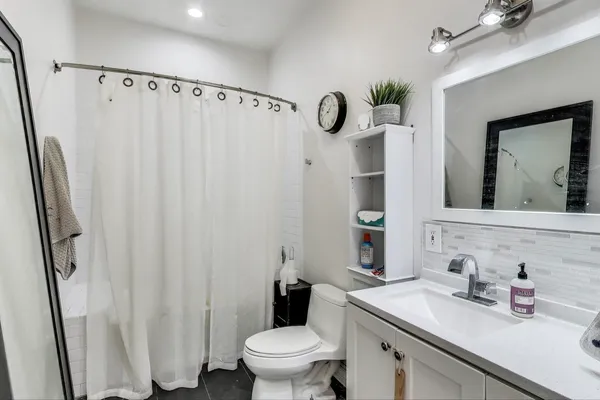 a bathroom with a sink a toilet and shower