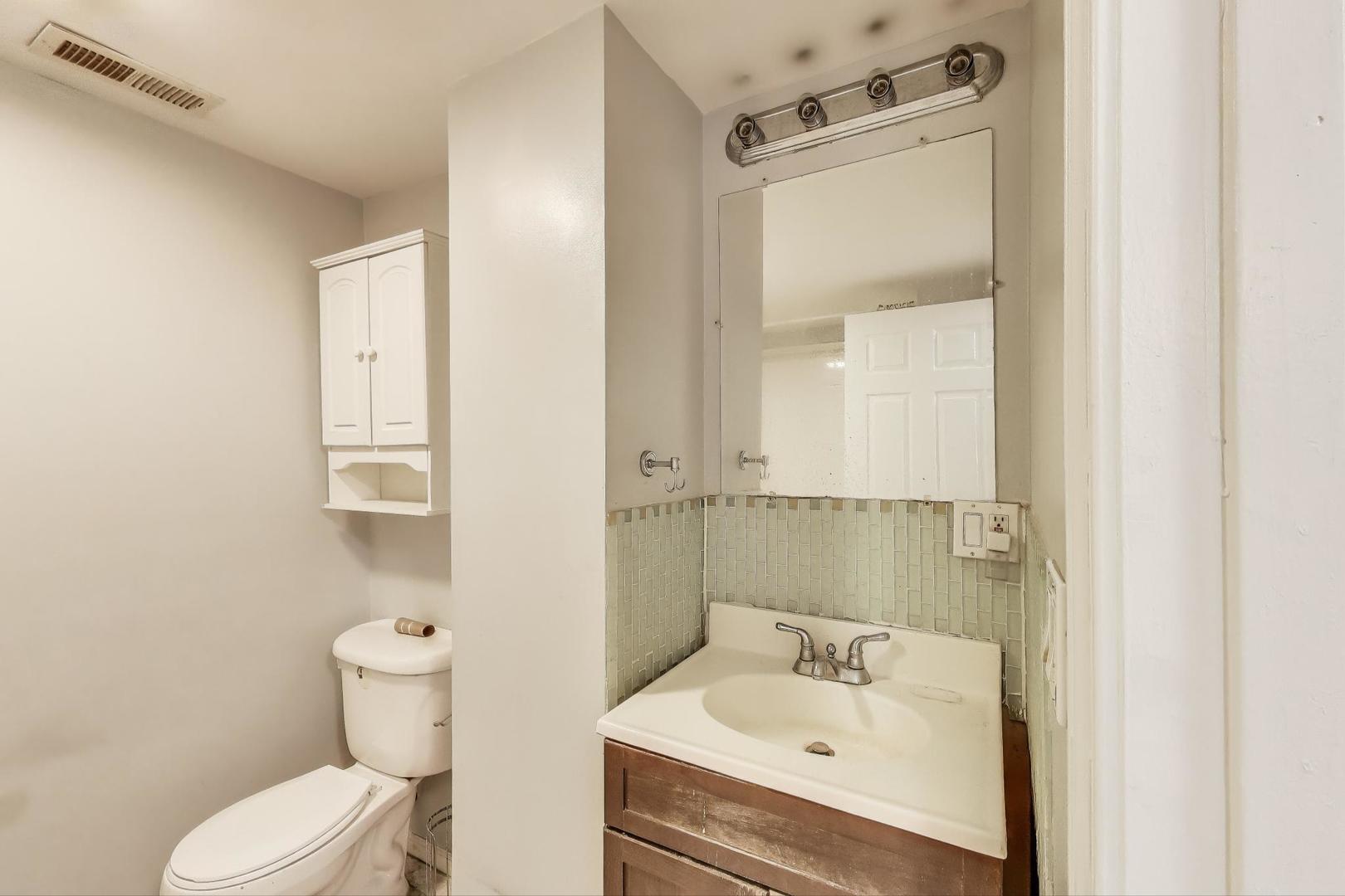 4553 South Ellis Avenue Chicago, IL 60653 - Photo 54 of 62 a bathroom with a sink a toilet and shower