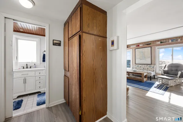 a bathroom with a toilet a sink a mirror a window and vanity