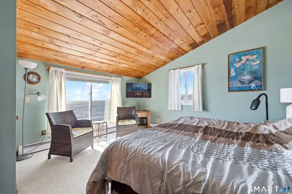 a bedroom with a large bed and a chandelier