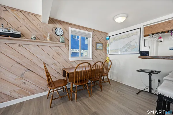 a kitchen with stainless steel appliances granite countertop a dining table chairs refrigerator and sink