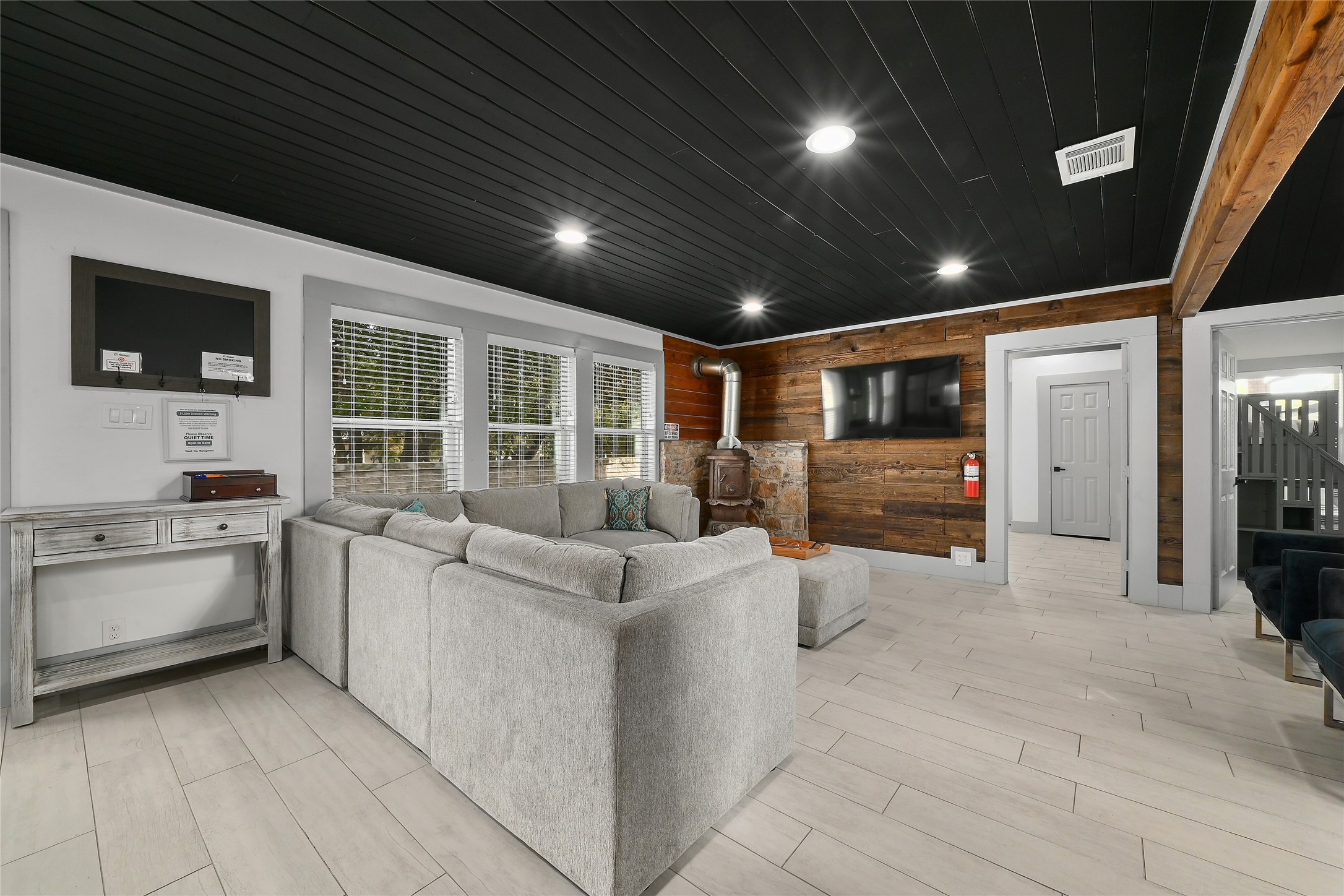 2903 Oak Ridge Drive Spicewood, TX 78669 - Photo 5 of 33 Main House Living room with wood walls, wood ceiling, wood tiled floors, and a wood stove