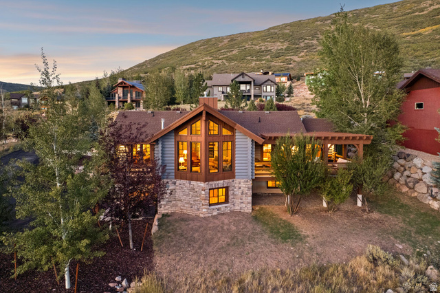 12465 Bone Road Kamas, UT 84036 - Photo 5 of 63 Stone and wood-sided exterior featuring multiple large windows, a prominent gable, and an attached covered deck