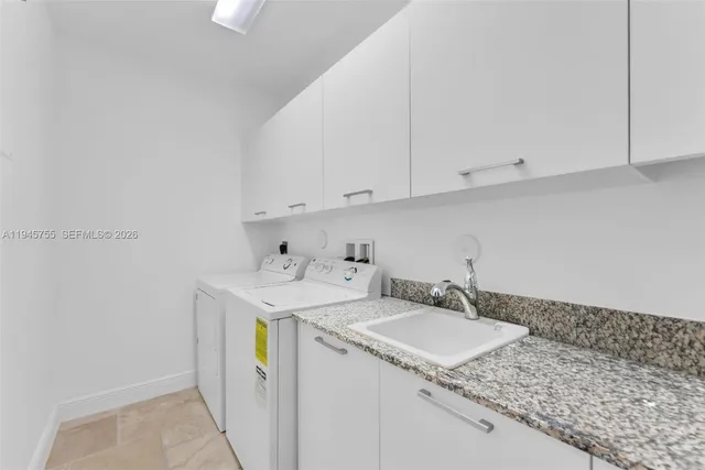 a utility room with sink dryer and washer