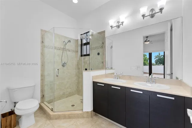 a bathroom with a shower sink vanity mirror and toilet