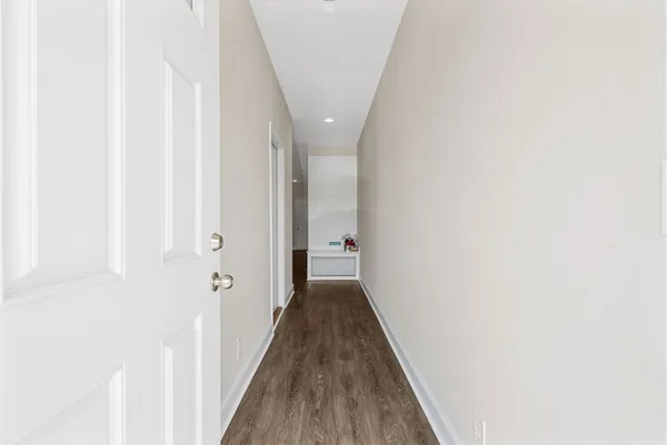 a view of a hallway with wooden floor