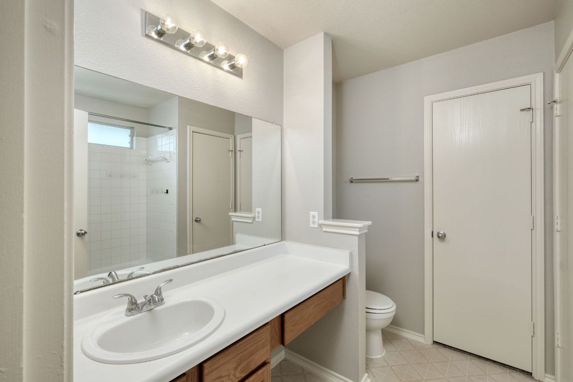 495 Atlantis Kyle, TX 78640 - Photo 6 of 14 a bathroom with a sink a toilet a mirror and shower