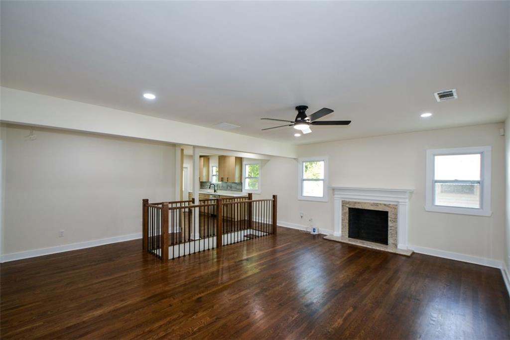1275 Westridge Road Southwest Atlanta, GA 30311 - Photo 7 of 38 an empty room with wooden floor fireplace and windows