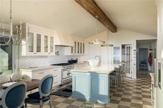 a kitchen with a stove a sink dishwasher a dining table and chairs with wooden floor