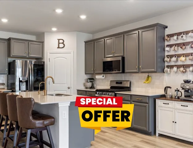 a kitchen with stainless steel appliances granite countertop a stove top oven a sink and a refrigerator