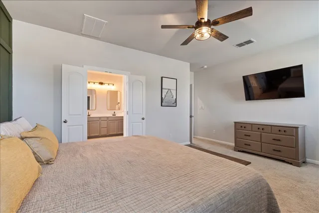 a spacious bedroom with a bed and a chandelier