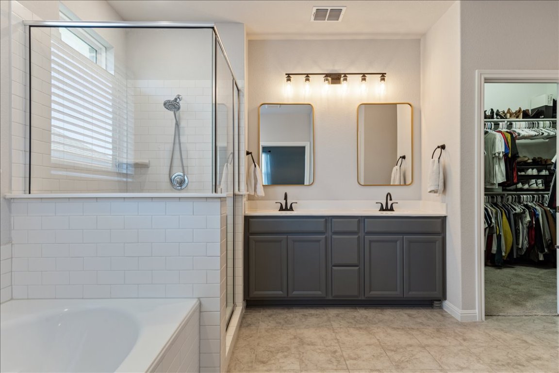 1001 A Dog Iron Street Georgetown, TX 78633 - Photo 13 of 25 a bathroom with a double vanity sink mirror and bathtub