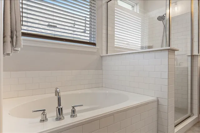 a bathroom with a double vanity sink mirror and bathtub