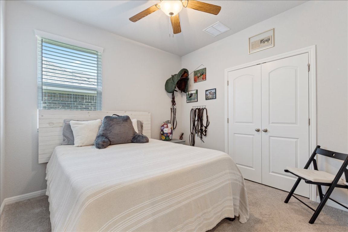 1001 A Dog Iron Street Georgetown, TX 78633 - Photo 23 of 25 a bedroom with a bed and a chandelier