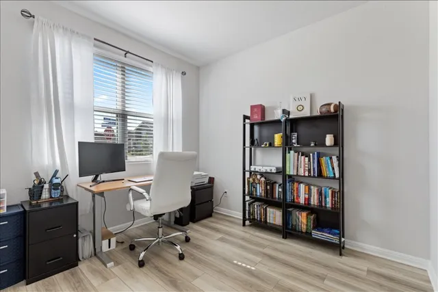 a view of a workspace with furniture and a window
