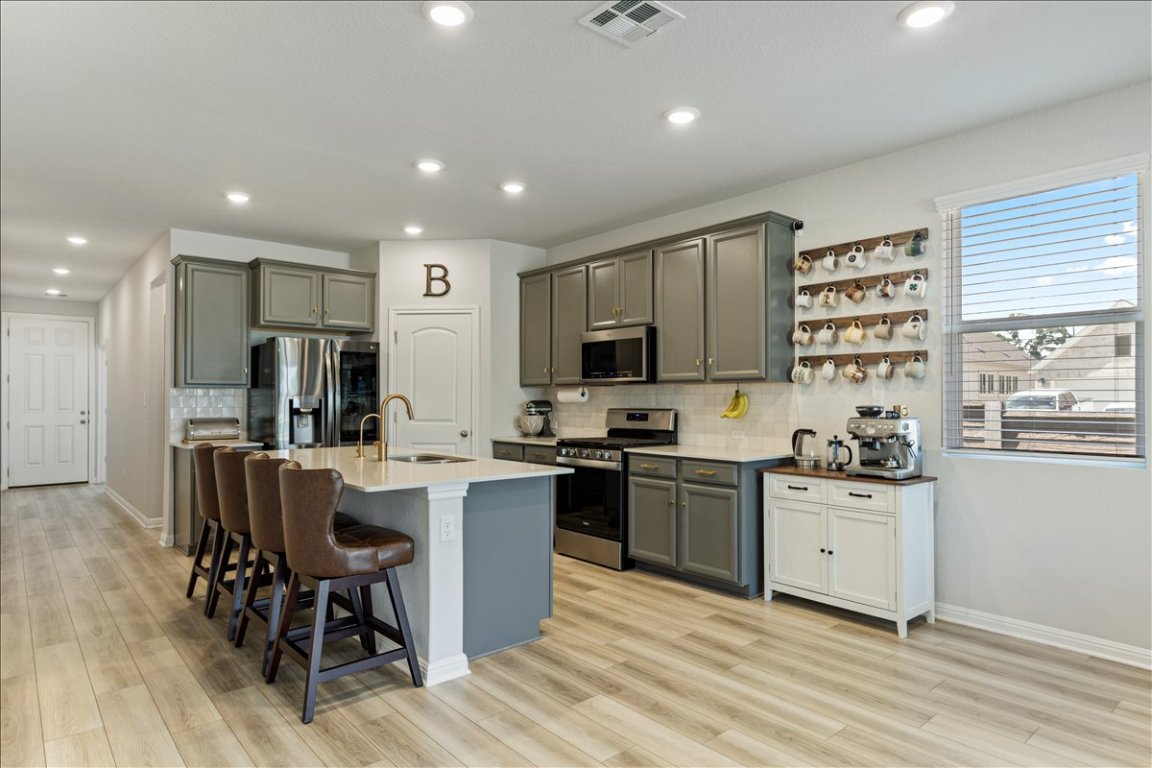 1001 A Dog Iron Street Georgetown, TX 78633 - Photo 4 of 25 a kitchen with stainless steel appliances kitchen island granite countertop a sink and cabinets
