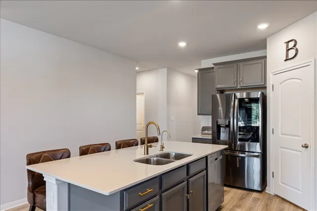 a kitchen with a sink a counter top space a stove and a refrigerator