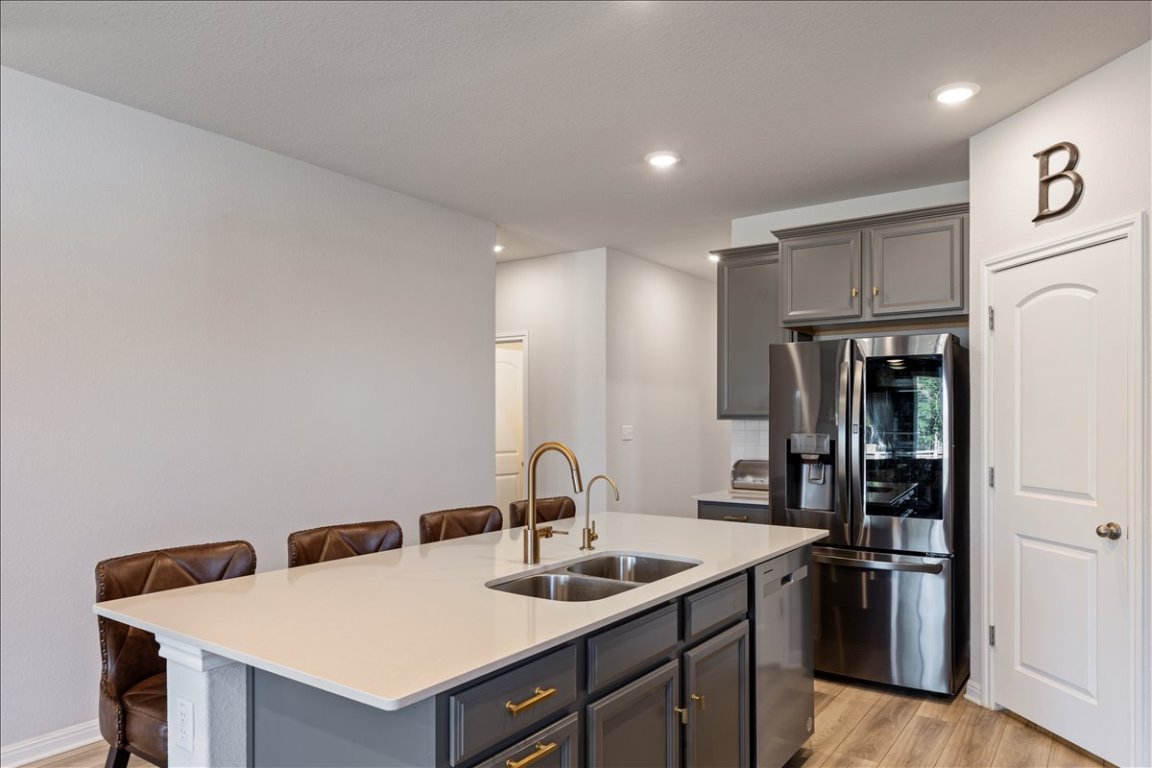 1001 A Dog Iron Street Georgetown, TX 78633 - Photo 7 of 25 a kitchen with a sink a refrigerator and cabinets