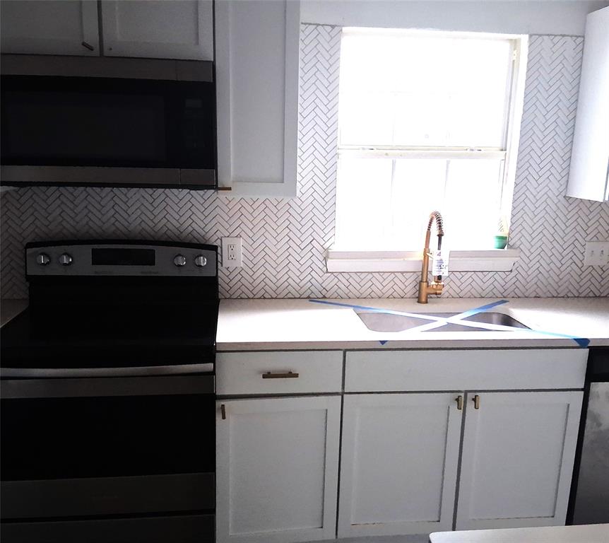 820 Allen Street Denton, TX 76205 - Photo 5 of 14 a kitchen with a sink stove and microwave